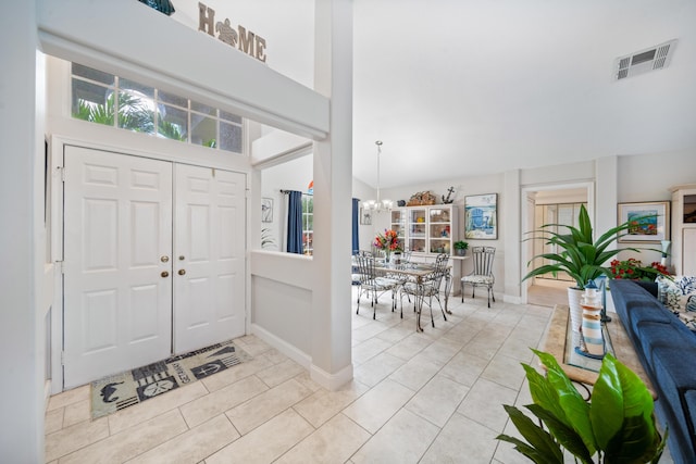 tiled entryway featuring an inviting chandelier