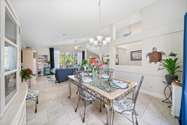 tiled dining space featuring ceiling fan with notable chandelier and lofted ceiling