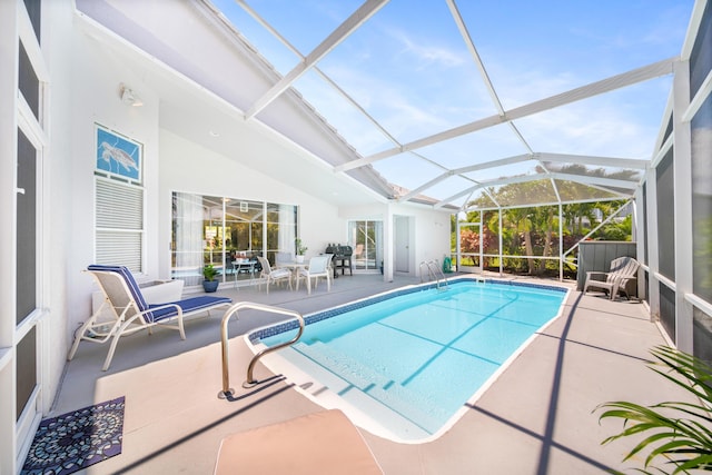 view of swimming pool featuring glass enclosure and a patio area