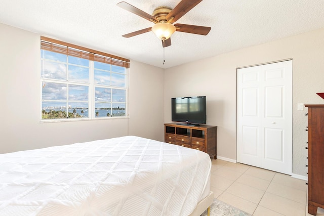 1801 N Flagler Dr Unit 840, West Palm Beach, FL 33407 - bedroom featuring light tile patterned floors, a ceiling fan, a textured ceiling, and baseboards