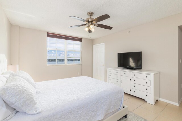 tiled bedroom featuring a textured ceiling and ceiling fan