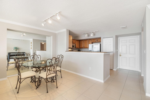 1801 N Flagler Dr Unit 840, West Palm Beach, FL 33407 - dining space featuring rail lighting, a textured ceiling, baseboards, light tile patterned floors, and ornamental molding