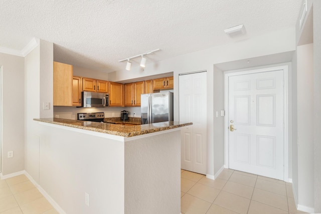 1801 N Flagler Dr Unit 840, West Palm Beach, FL 33407 - kitchen with stainless steel appliances, track lighting, light tile patterned floors, dark stone countertops, and a textured ceiling