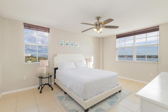 1801 N Flagler Dr Unit 840, West Palm Beach, FL 33407 - bedroom with multiple windows, baseboards, light tile patterned floors, and ceiling fan