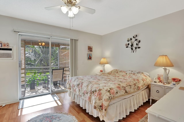 bedroom with hardwood / wood-style floors, ceiling fan, a wall mounted air conditioner, and access to outside