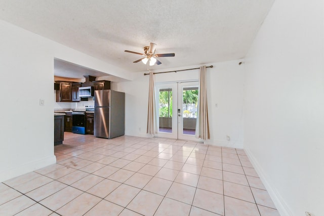 unfurnished living room with ceiling fan, french doors, light tile patterned floors, and a textured ceiling