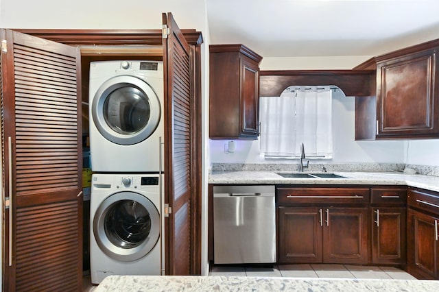 laundry room featuring stacked washer and dryer, sink, and light tile patterned floors