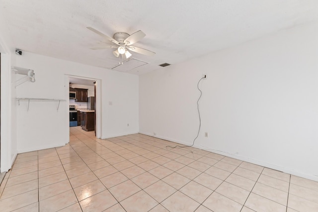 tiled spare room featuring ceiling fan