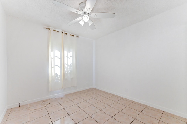 unfurnished room with ceiling fan, light tile patterned flooring, and a textured ceiling