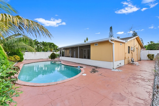 view of swimming pool with a patio area and a sunroom