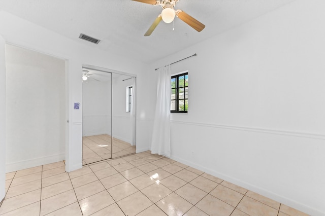 unfurnished bedroom featuring ceiling fan and light tile patterned flooring