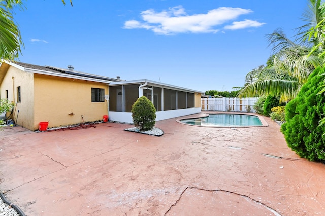 view of pool with a sunroom and a patio area