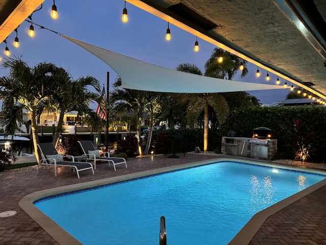 view of pool featuring area for grilling and a patio