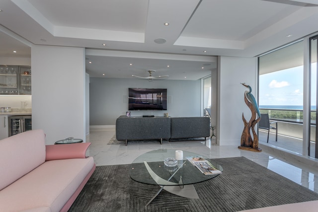 living room with beverage cooler, a raised ceiling, and bar area