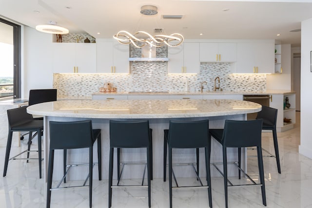 kitchen featuring a kitchen breakfast bar, white cabinetry, black electric cooktop, and decorative backsplash