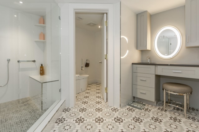 bathroom featuring vanity, tiled shower, and toilet