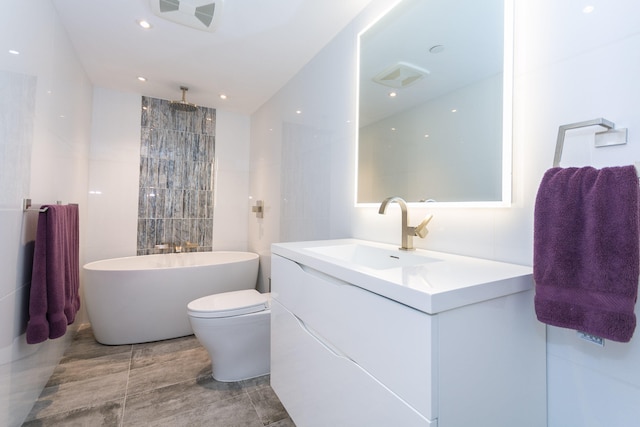 full bathroom featuring vanity, shower with separate bathtub, tile walls, and toilet