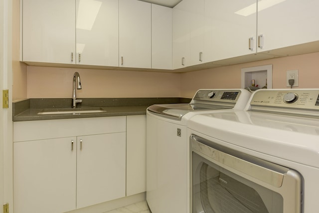 laundry area featuring washer and dryer, sink, and cabinets