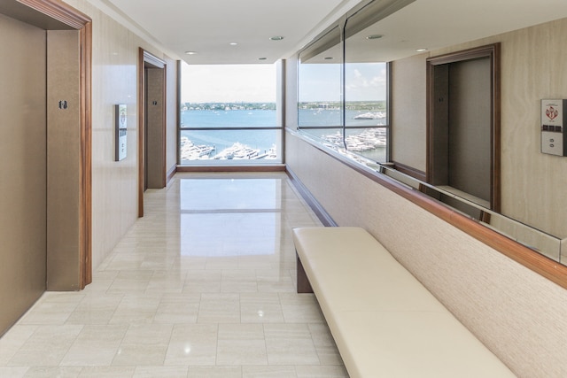 corridor featuring a water view and elevator