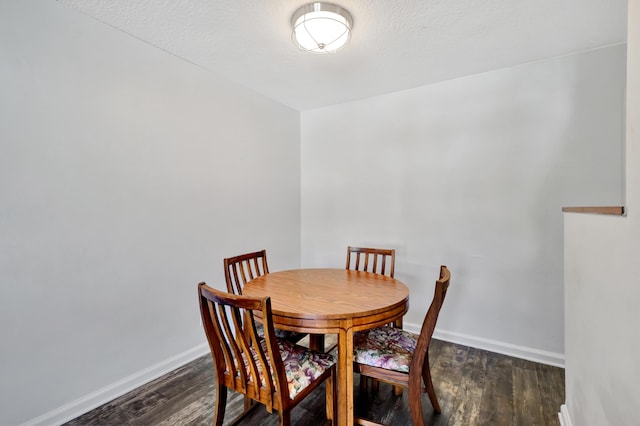 dining room with dark hardwood / wood-style flooring and a textured ceiling