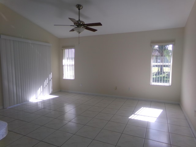 empty room with ceiling fan, light tile patterned floors, and a healthy amount of sunlight