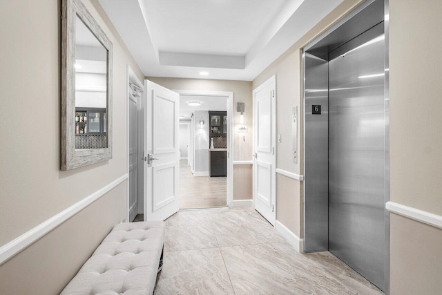 bathroom featuring a tray ceiling and elevator