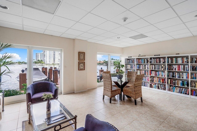 dining area featuring a drop ceiling and a water view