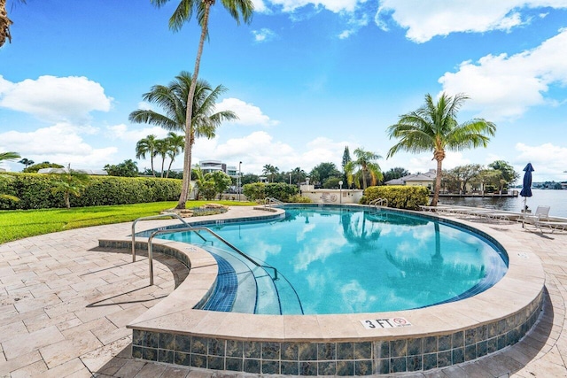 view of pool featuring a patio area and a water view