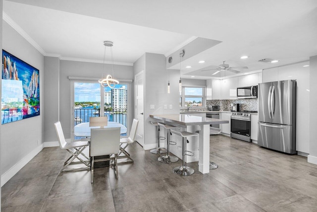 dining space featuring ceiling fan and crown molding