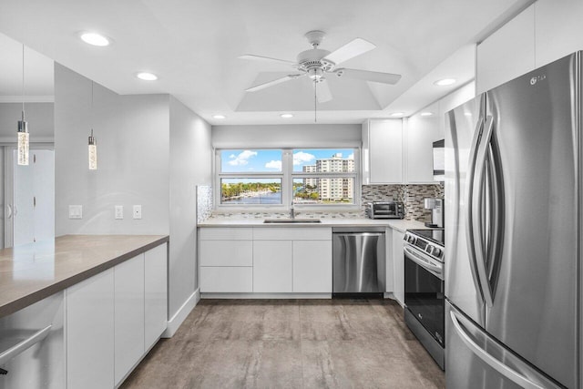 kitchen featuring pendant lighting, white cabinets, sink, tasteful backsplash, and stainless steel appliances