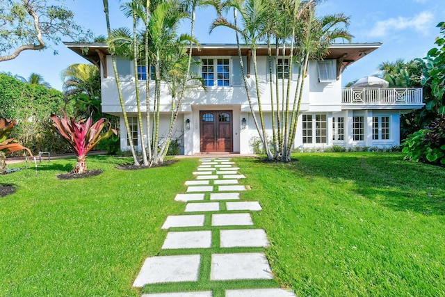 view of front of house featuring a front yard and a balcony