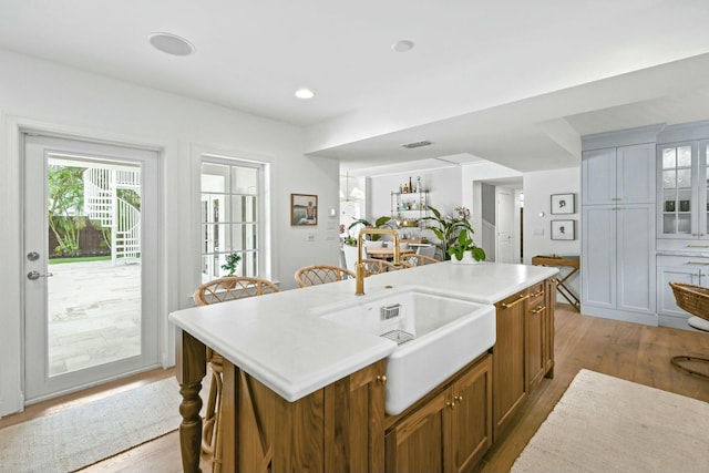 kitchen with a kitchen island with sink and light hardwood / wood-style flooring