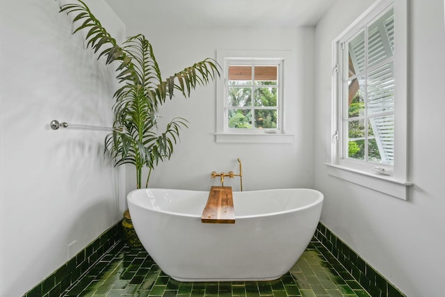 bathroom with tile patterned flooring and a bath