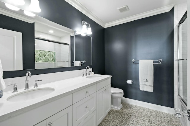 bathroom with a shower with door, crown molding, vanity, and toilet