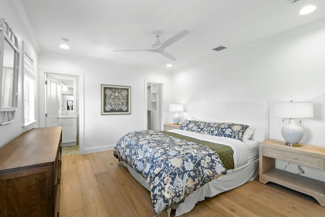 bedroom featuring ensuite bathroom, crown molding, a walk in closet, light hardwood / wood-style flooring, and ceiling fan