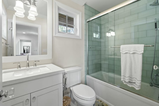 full bathroom featuring vanity, ornamental molding, enclosed tub / shower combo, and toilet