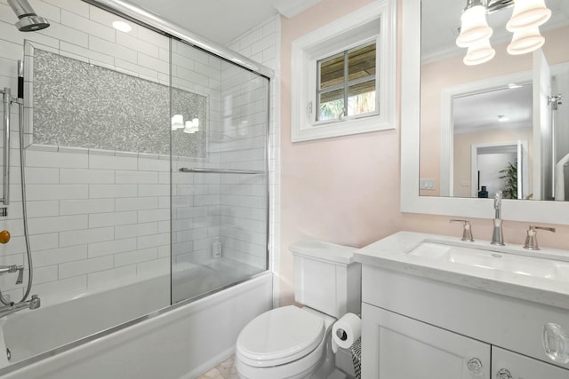 full bathroom with vanity, bath / shower combo with glass door, ornamental molding, and toilet