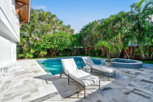 view of pool with an in ground hot tub and a patio