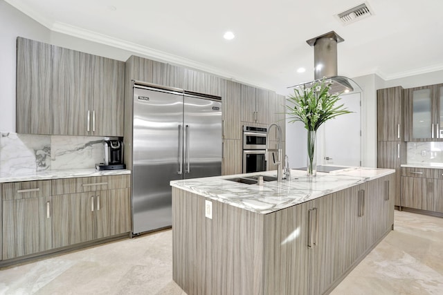 kitchen featuring light stone countertops, a large island, sink, stainless steel appliances, and decorative backsplash