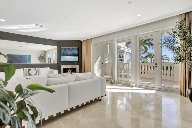 living room featuring french doors, ornamental molding, and a fireplace