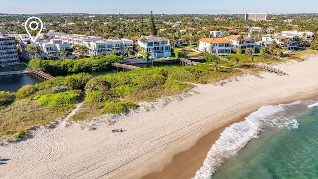 birds eye view of property with a water view and a beach view