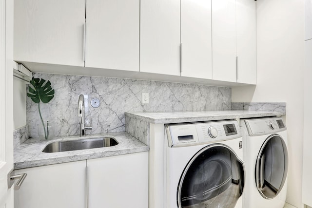 clothes washing area featuring cabinets, separate washer and dryer, and sink