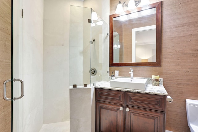 bathroom featuring vanity, an enclosed shower, and toilet