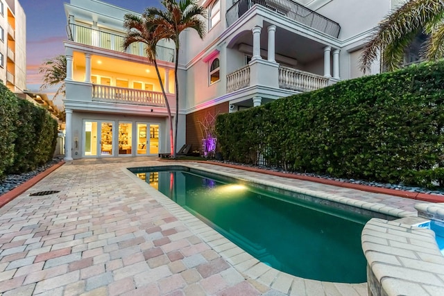 pool at dusk featuring a patio area