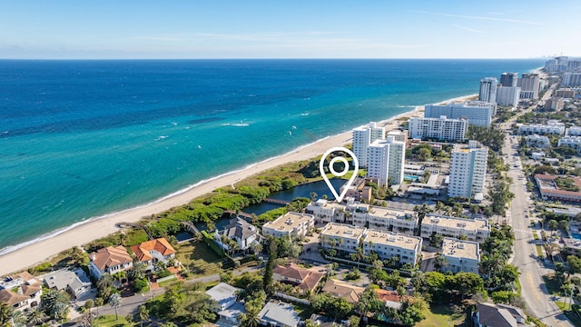 drone / aerial view featuring a water view and a view of the beach