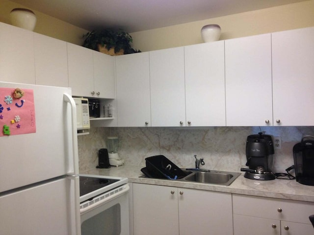 kitchen with decorative backsplash, sink, white cabinets, and white appliances