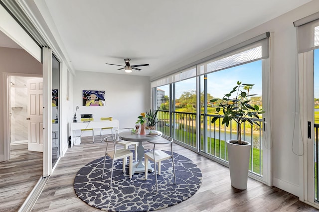 sunroom / solarium featuring a ceiling fan