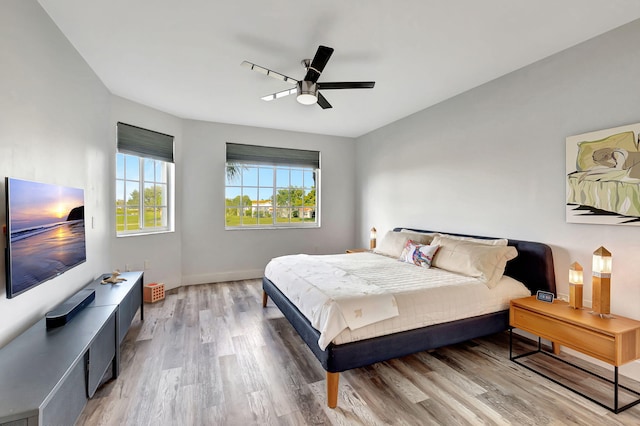 bedroom with baseboards, light wood-style floors, and ceiling fan