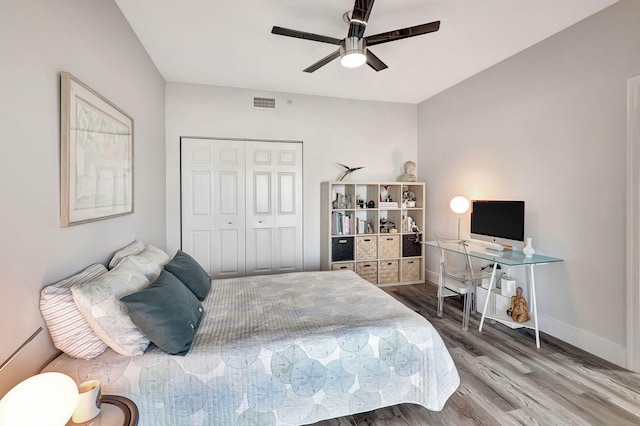 bedroom featuring visible vents, ceiling fan, baseboards, wood finished floors, and a closet