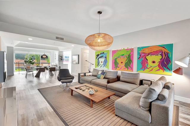 living area featuring visible vents, recessed lighting, baseboards, and wood finished floors